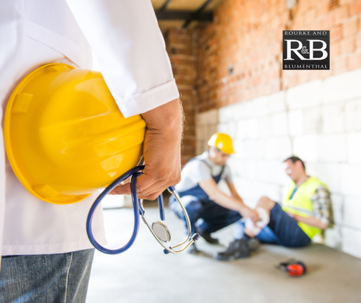 Injured construction worker in the background and doctor holding a hard hat in the foreground | Rourke & Blumenthal